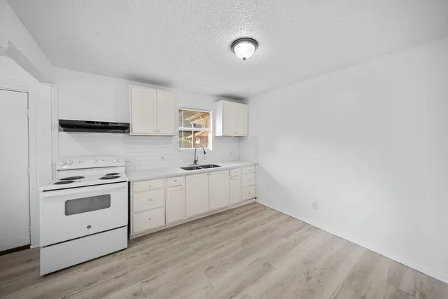 a kitchen with granite countertop white cabinets and white appliances