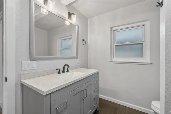 a bathroom with a sink a vanity and a toilet