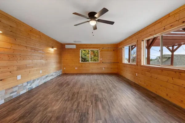 a view of empty room with wooden floor and fan