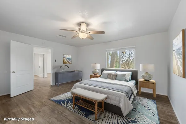 a bedroom with a bed wooden floor and a table