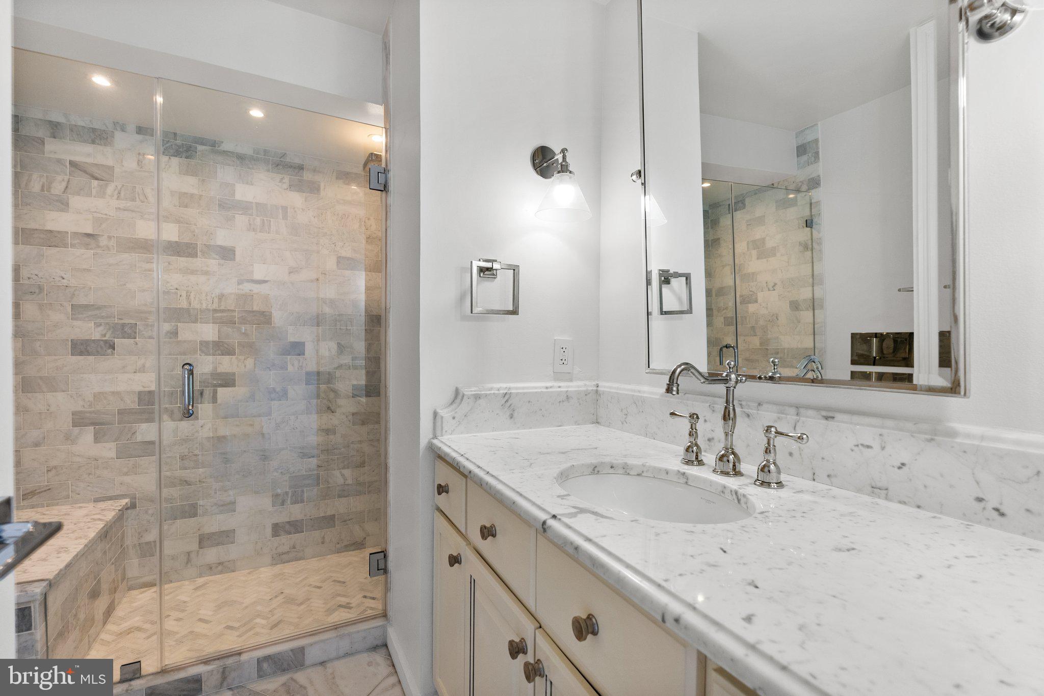 2500 Virginia Avenue Northwest, Unit 1005S Washington, DC 20037 - Photo 21 of 42 a bathroom with a granite countertop sink a shower and a mirror
