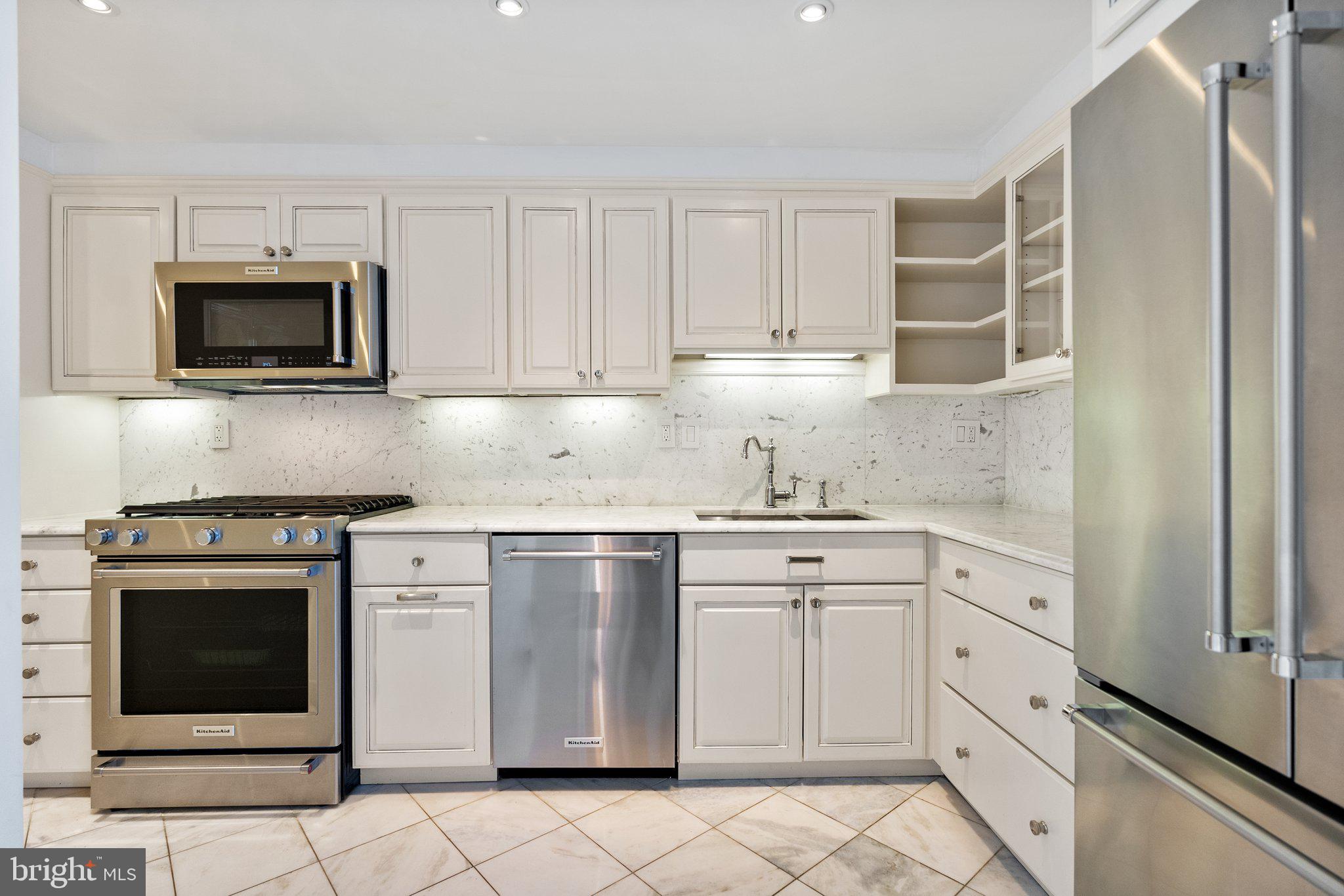 2500 Virginia Avenue Northwest, Unit 1005S Washington, DC 20037 - Photo 8 of 42 a kitchen with white cabinets and stainless steel appliances
