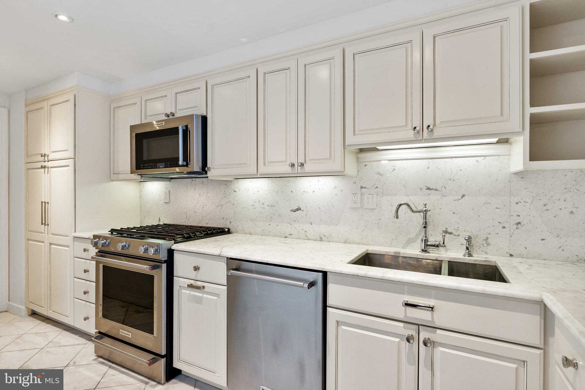 2500 Virginia Avenue Northwest, Unit 1005S Washington, DC 20037 - Photo 9 of 42 a kitchen with white cabinets and stainless steel appliances