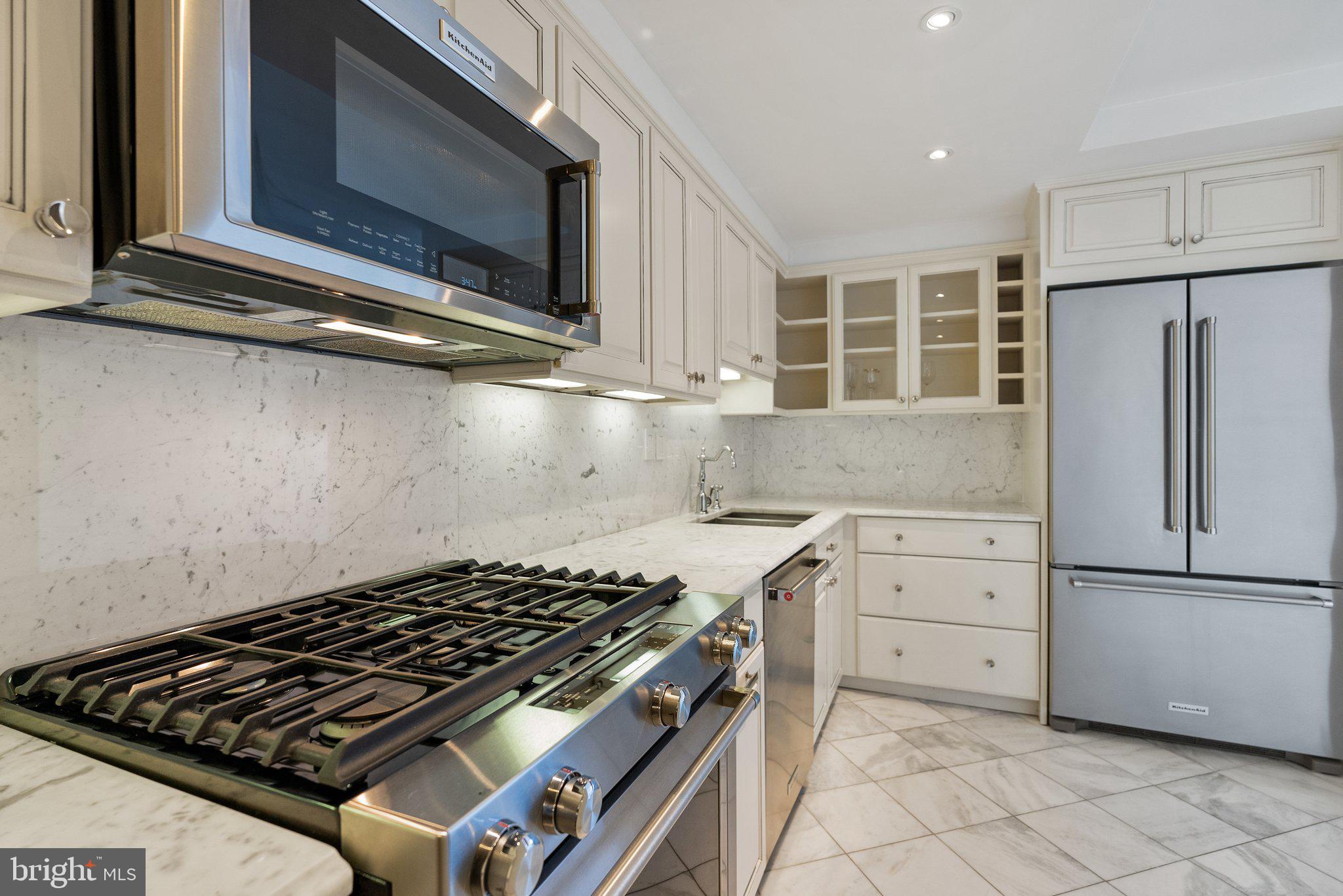 2500 Virginia Avenue Northwest, Unit 1005S Washington, DC 20037 - Photo 10 of 42 a kitchen with wooden cabinets and a stove top oven