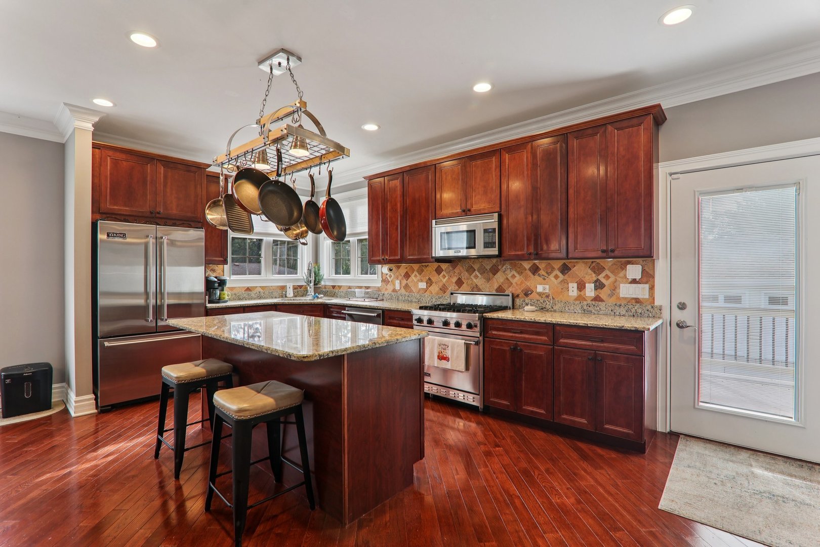 124 Hubbard Court Wauconda, IL 60084 - Photo 11 of 47 a kitchen with stainless steel appliances granite countertop wooden floor sink stove dining table and chairs