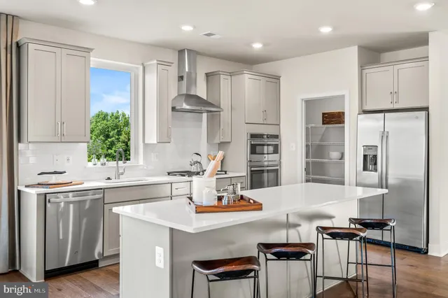 a kitchen with stainless steel appliances kitchen island granite countertop a sink and cabinets