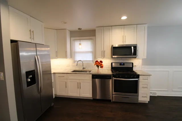 a kitchen with stainless steel appliances kitchen island granite countertop a stove and a refrigerator