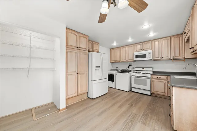 a kitchen with a white cabinets and wooden floor