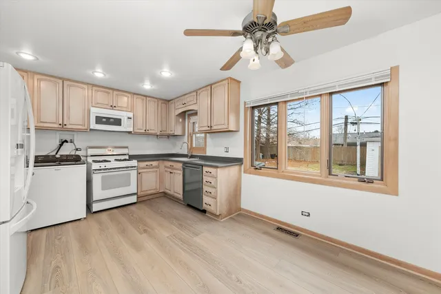 a kitchen with granite countertop white cabinets and white appliances