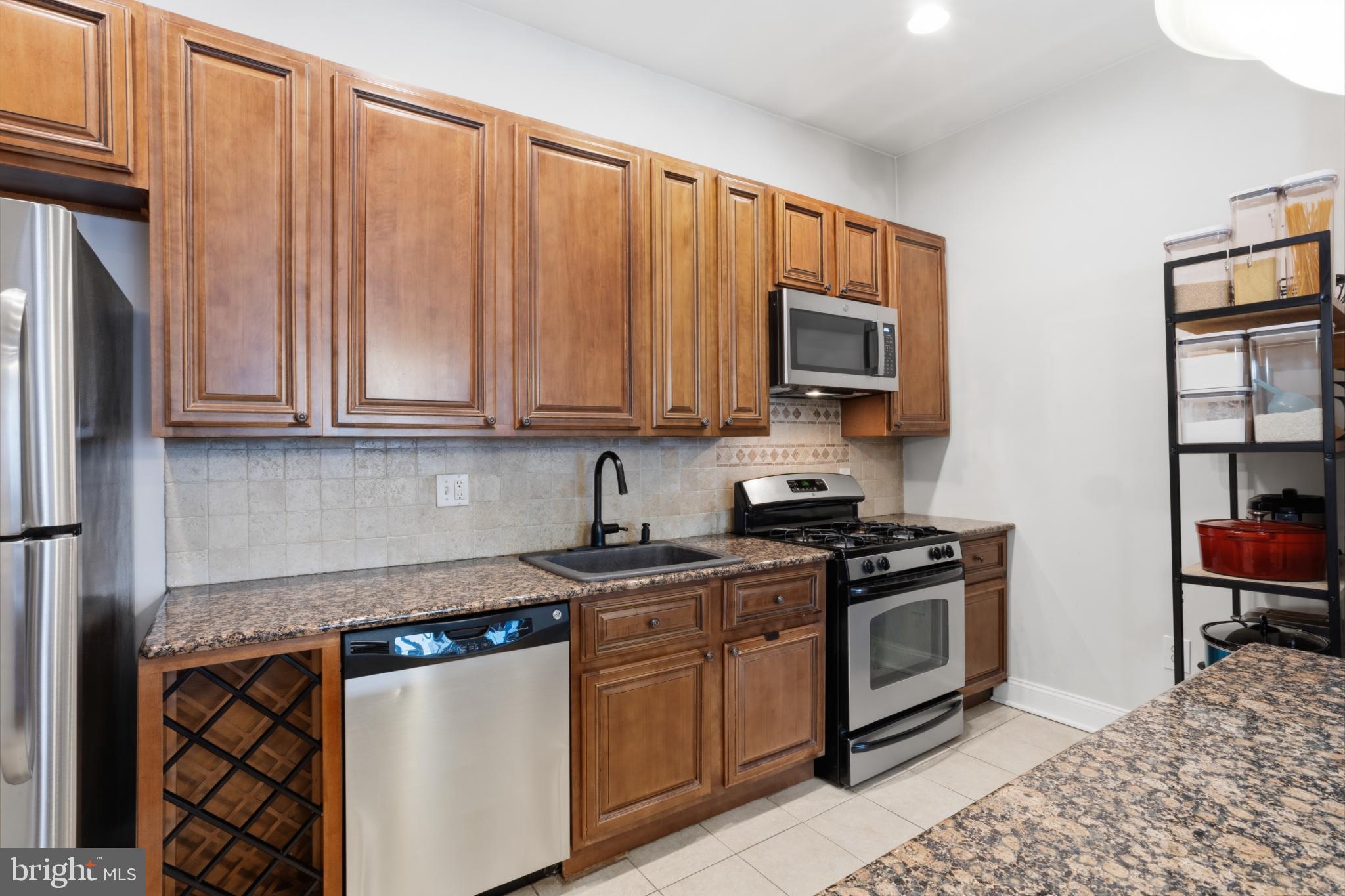 902 South 8th Street Philadelphia, PA 19147 - Photo 13 of 33 a kitchen with stainless steel appliances granite countertop a stove a sink and a refrigerator