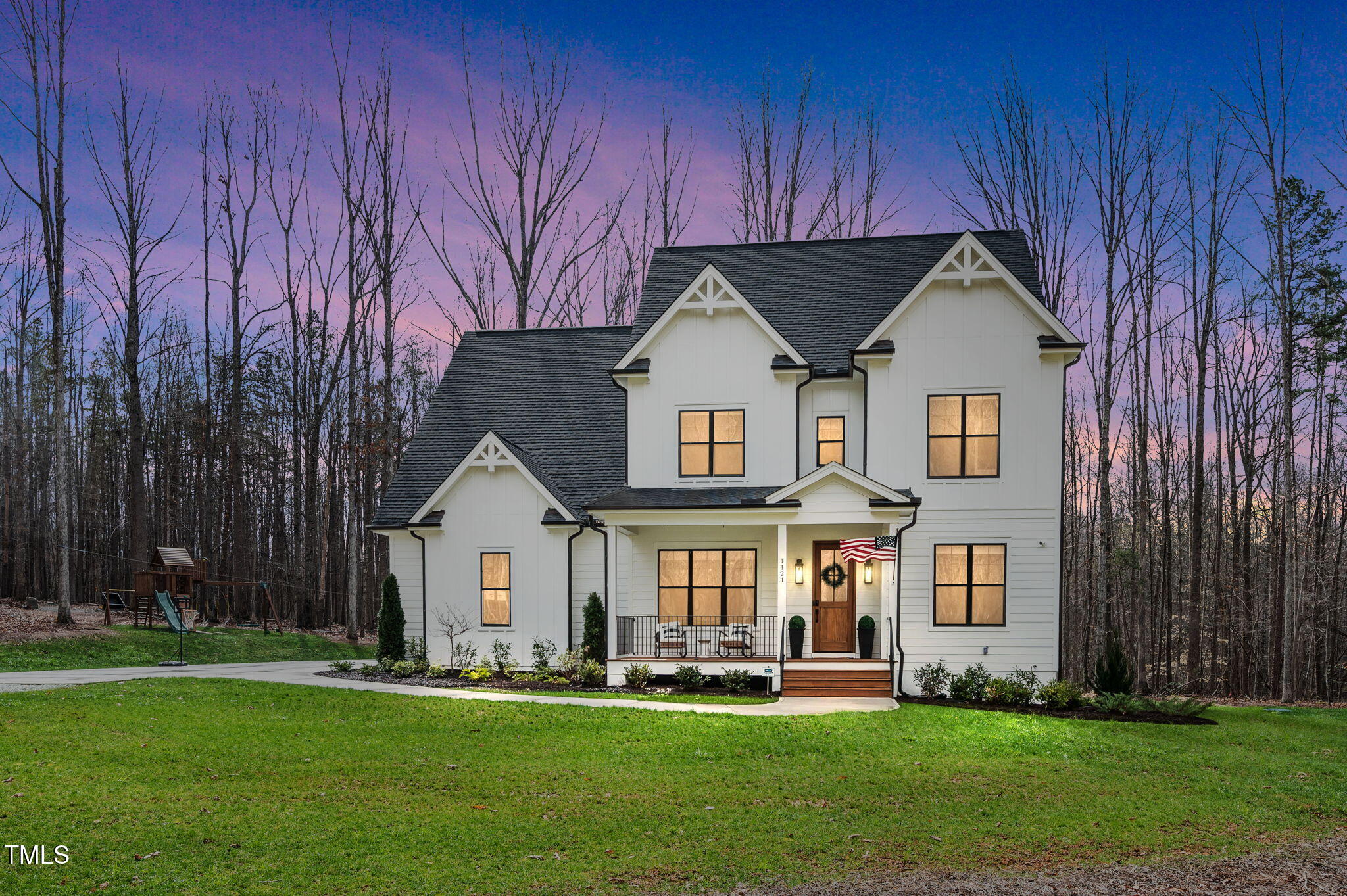 a front view of a house with a yard and trees