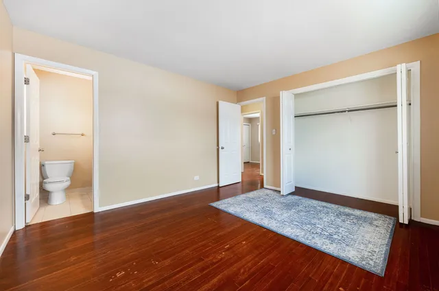 a view of an empty room with glass door and wooden floor