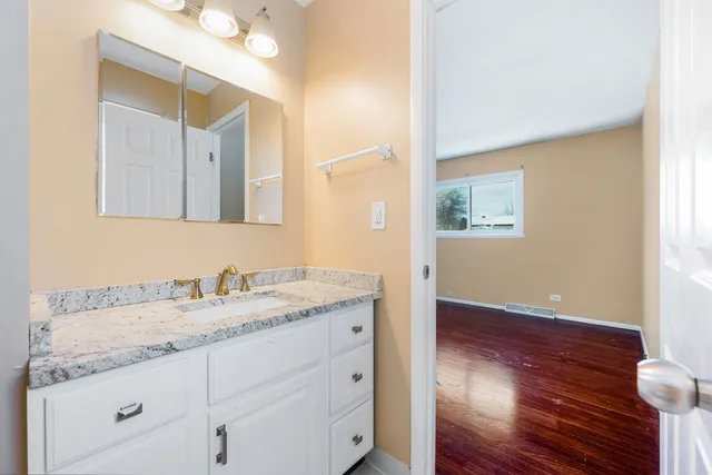 a bathroom with a granite countertop sink and a mirror