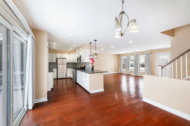 a view of a living room and kitchen with furniture wooden floor