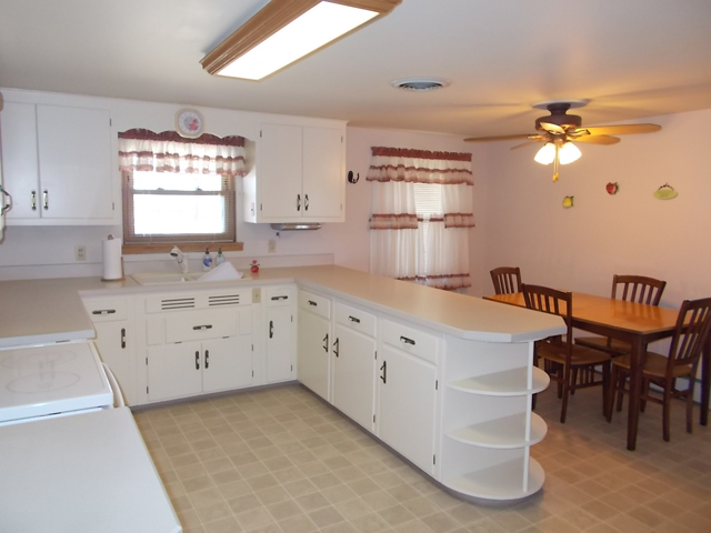 201 Maple Street Cedar Point, IL 61316 - Photo 4 of 12 a kitchen with granite countertop a window and white cabinets