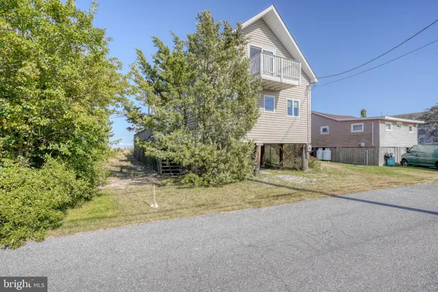 a view of a house with a yard and pathway