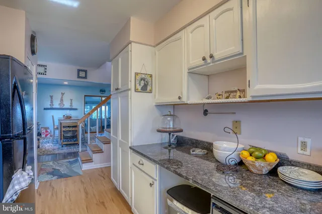 a kitchen with stainless steel appliances granite countertop a sink a stove and a wooden floors