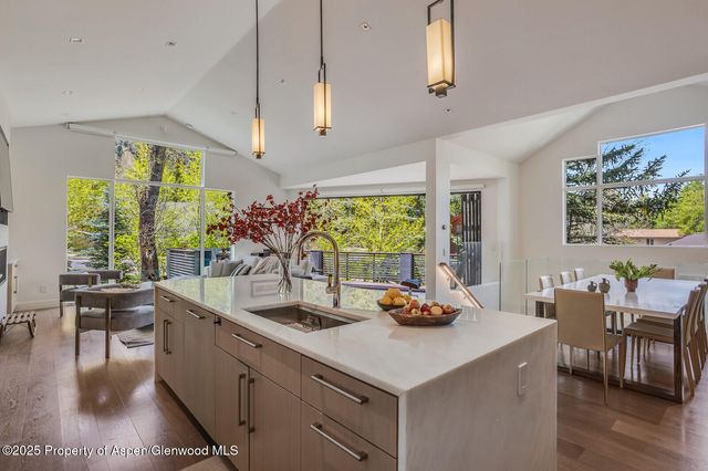 a kitchen with a stove a refrigerator and a dining table with wooden floor