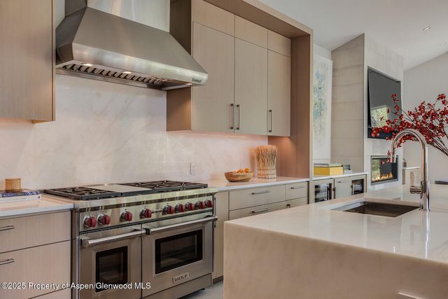 a kitchen with granite countertop a sink a stove and cabinets