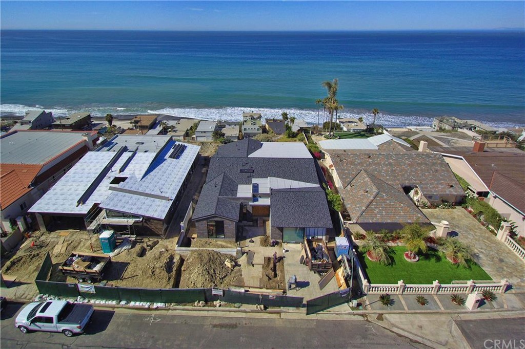 Subject property is to the left of the green grass. Property with the white truck and white roof are not part of this offering.