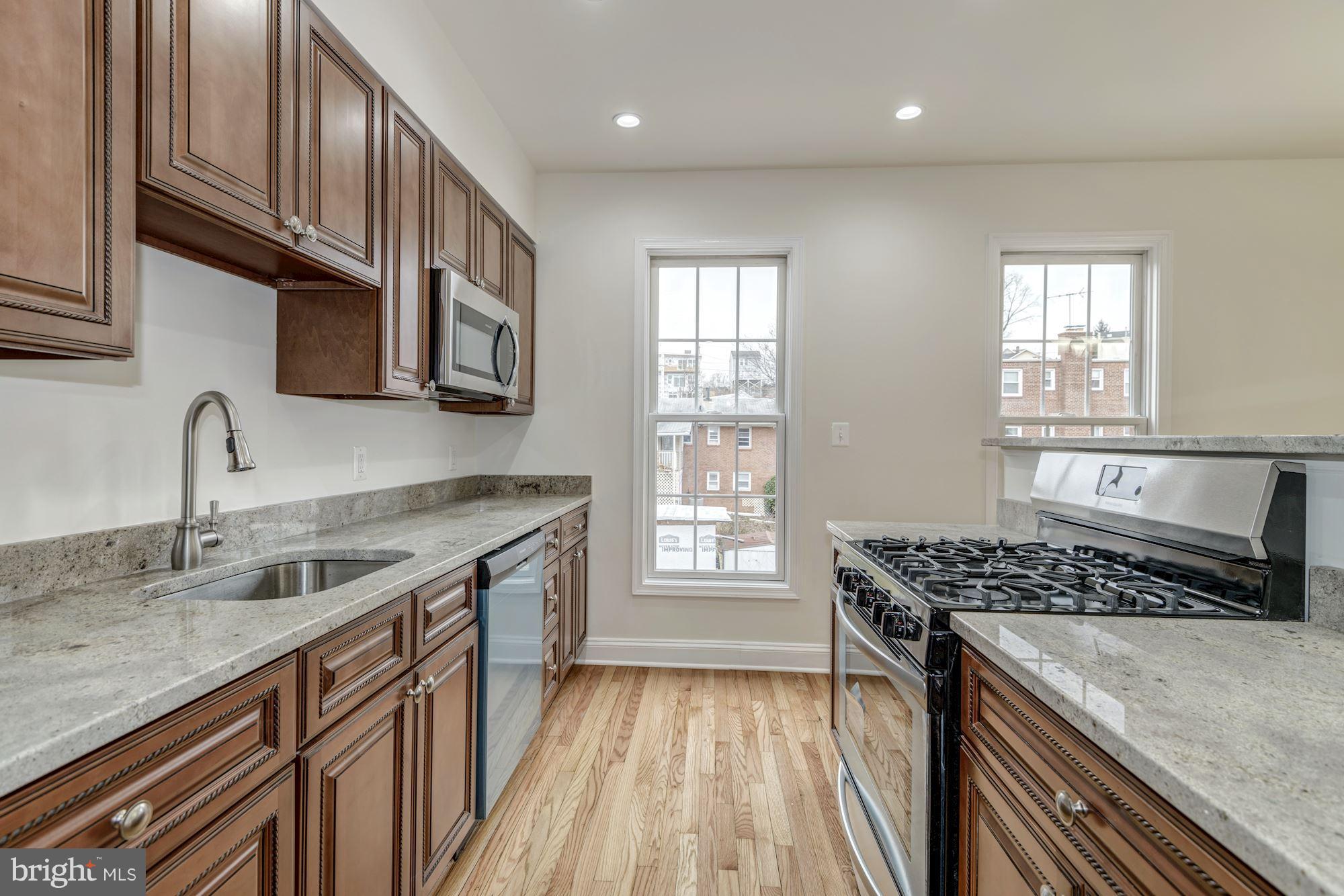 2016 South Glebe Road Arlington, VA 22204 - Photo 10 of 27 a kitchen with stainless steel appliances granite countertop a sink stove and cabinets