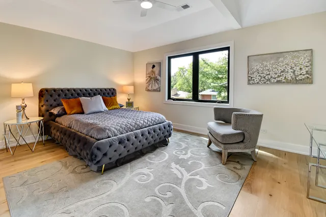 a bedroom with a bed chair and a window