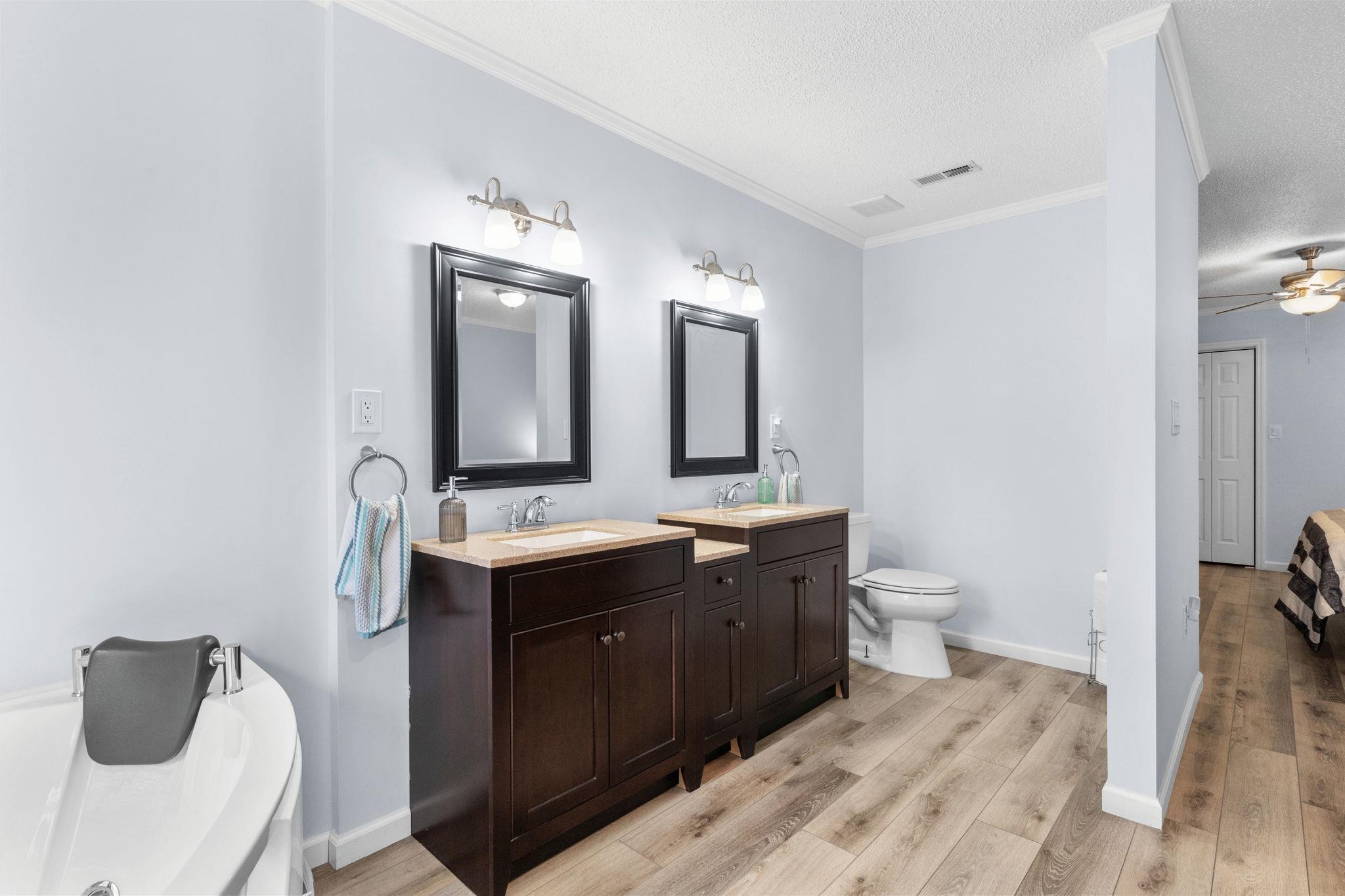 2981 Victor Road Longs, SC 29568 - Photo 19 of 32 Bathroom with two vanities, light wood finished floors, crown molding, a ceiling fan, and a bath