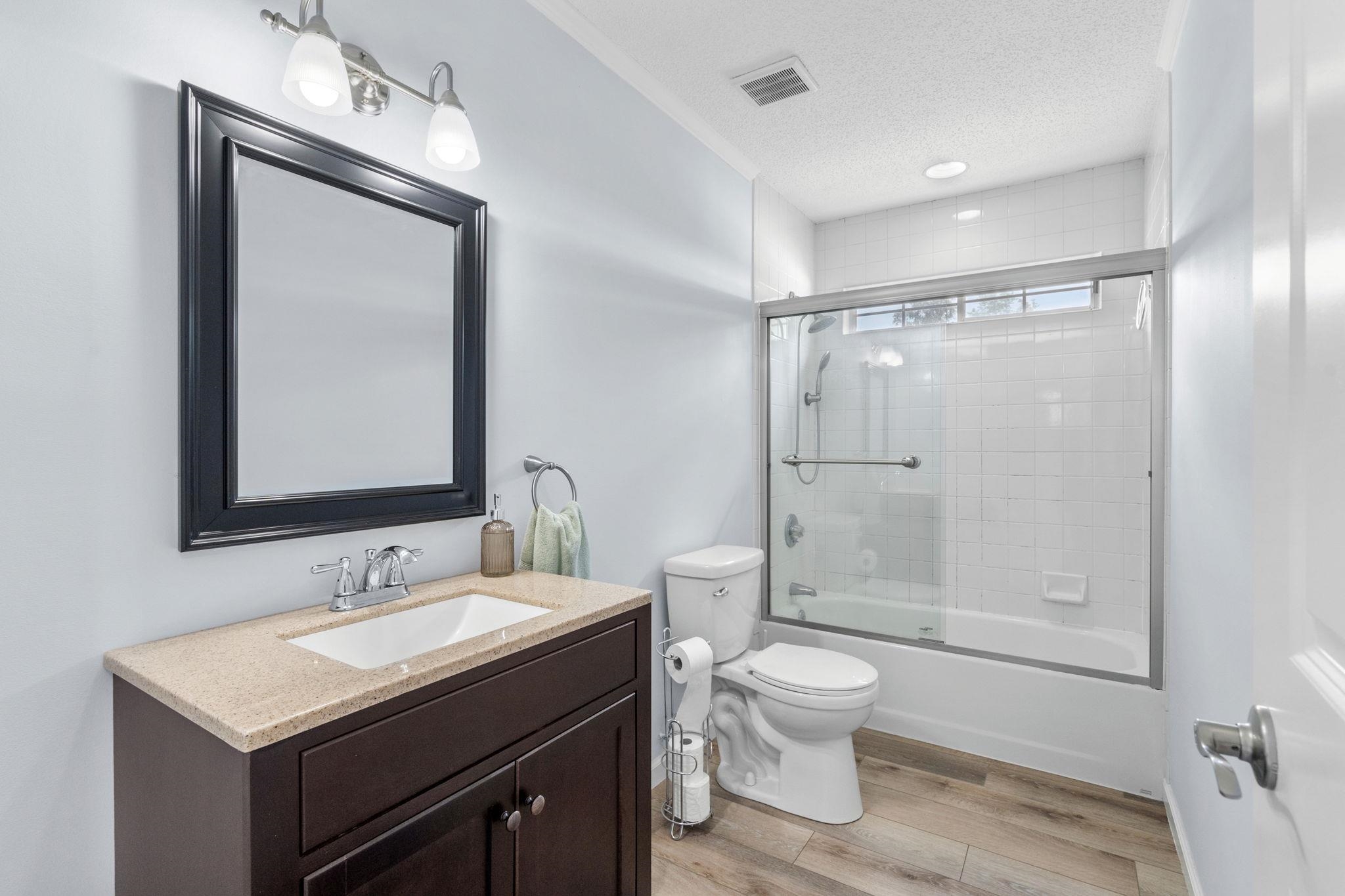 2981 Victor Road Longs, SC 29568 - Photo 28 of 32 Full bath featuring vanity, combined bath / shower with glass door, light wood finished floors, and a textured ceiling