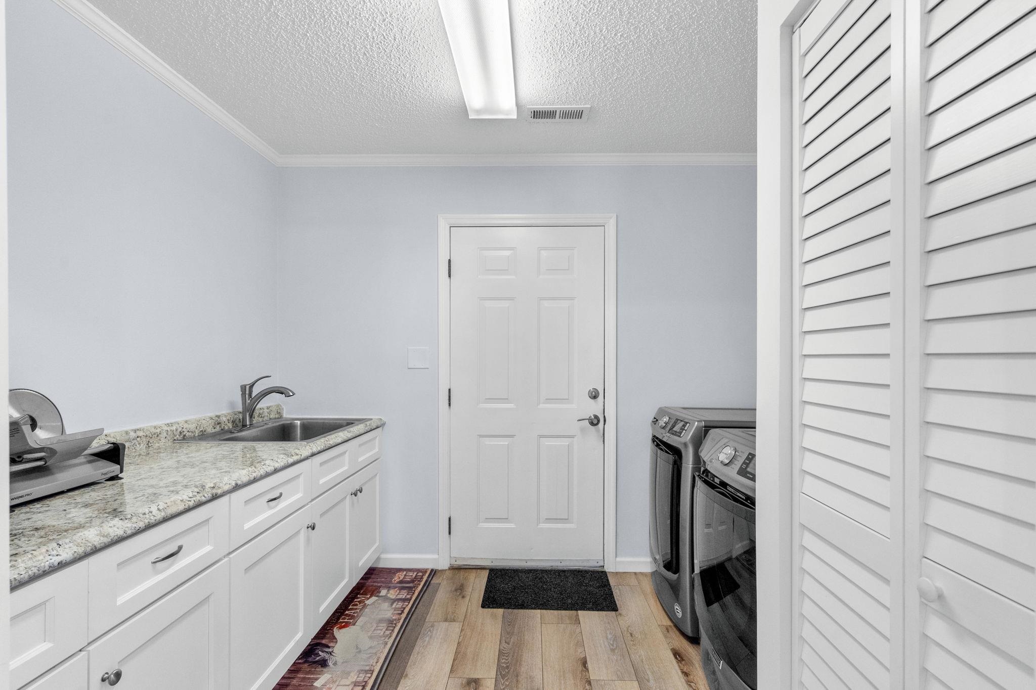 2981 Victor Road Longs, SC 29568 - Photo 29 of 32 Washroom featuring light wood-style flooring, washing machine and dryer, a textured ceiling, and crown molding