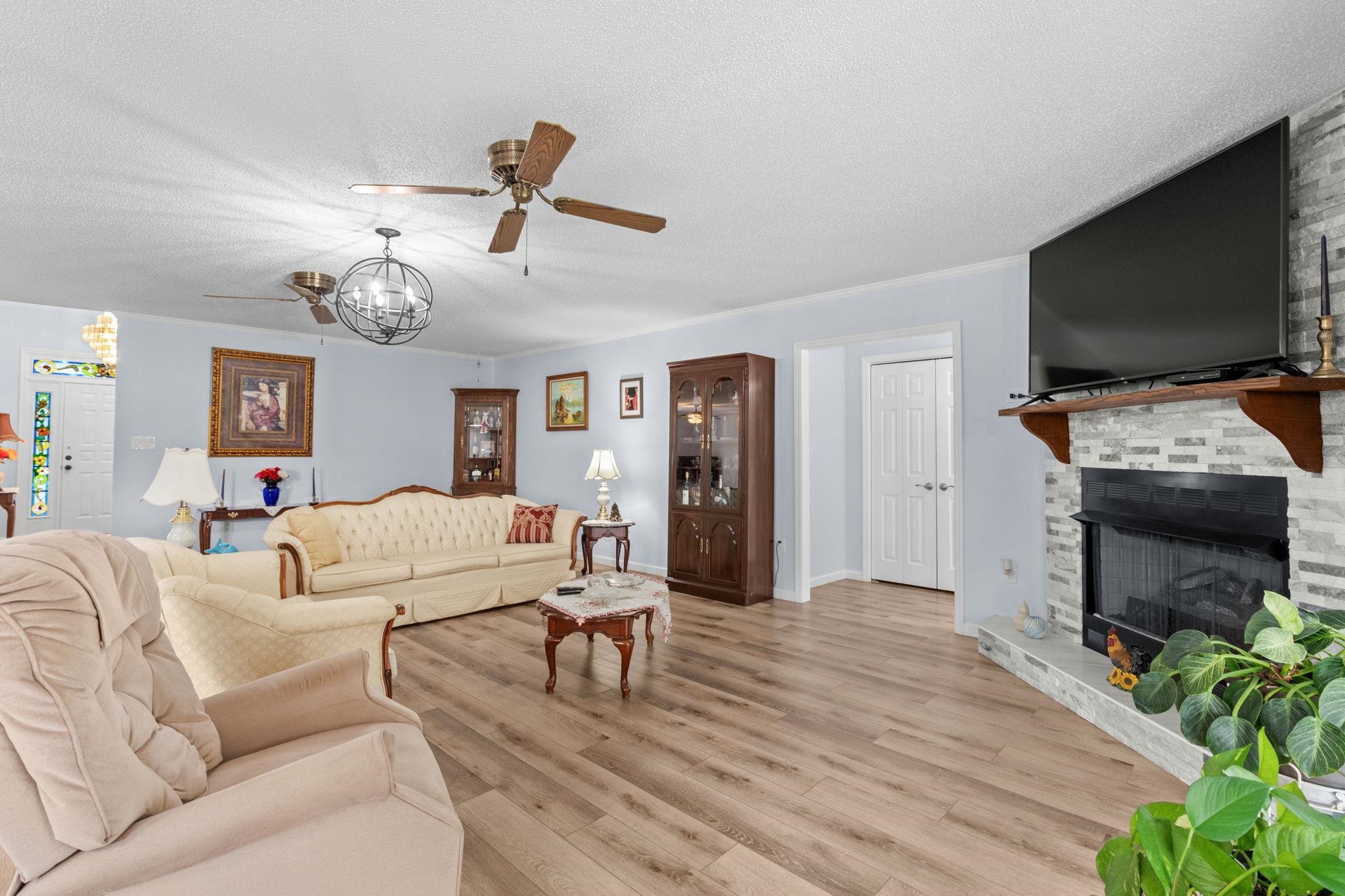 2981 Victor Road Longs, SC 29568 - Photo 8 of 32 Living room featuring wood finished floors, a fireplace with raised hearth, ceiling fan, and a textured ceiling