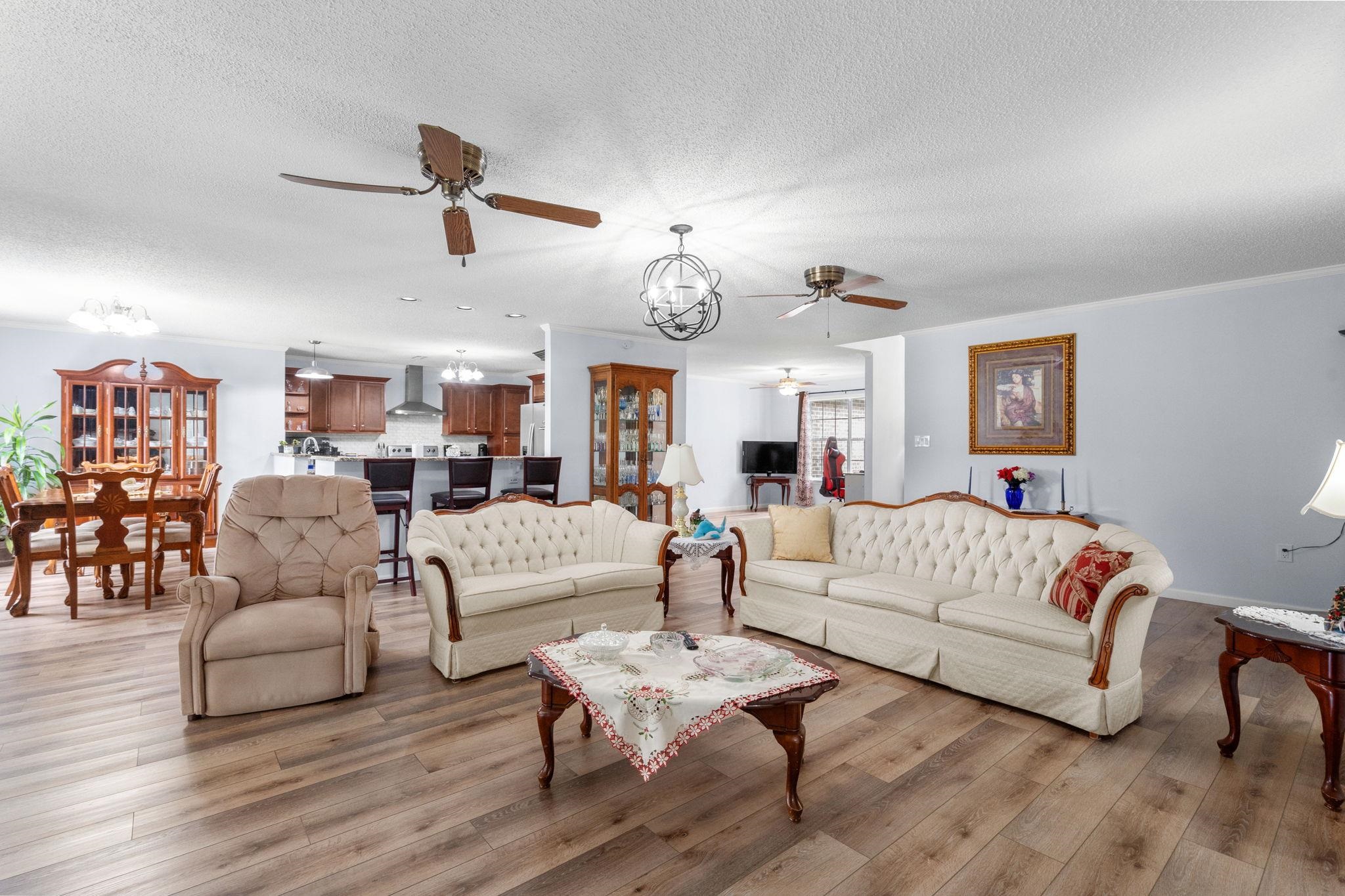 2981 Victor Road Longs, SC 29568 - Photo 9 of 32 Living area with a chandelier, light wood-style flooring, a textured ceiling, and ceiling fan
