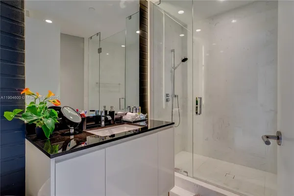 a bathroom with a double vanity sink a mirror and a shower