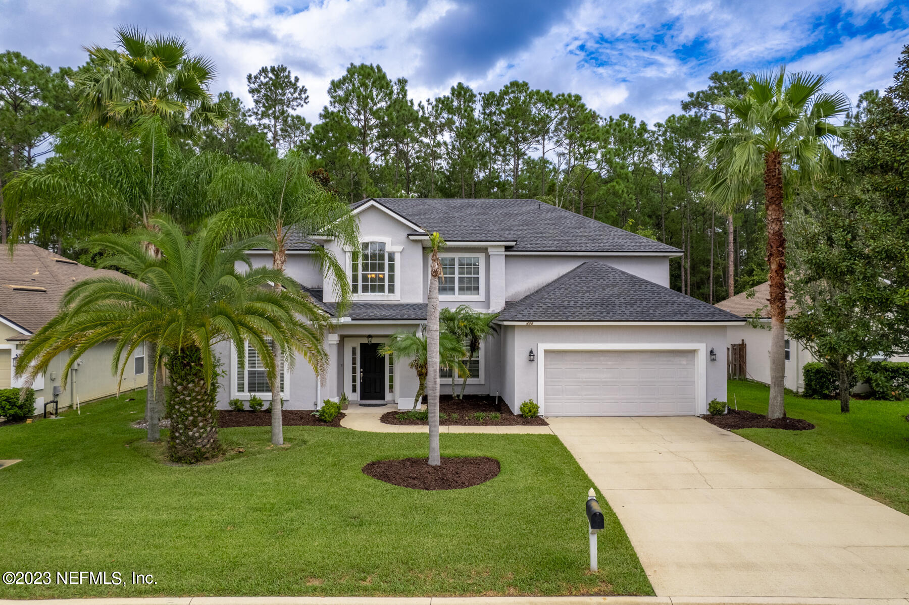a front view of a house with a yard and a garage