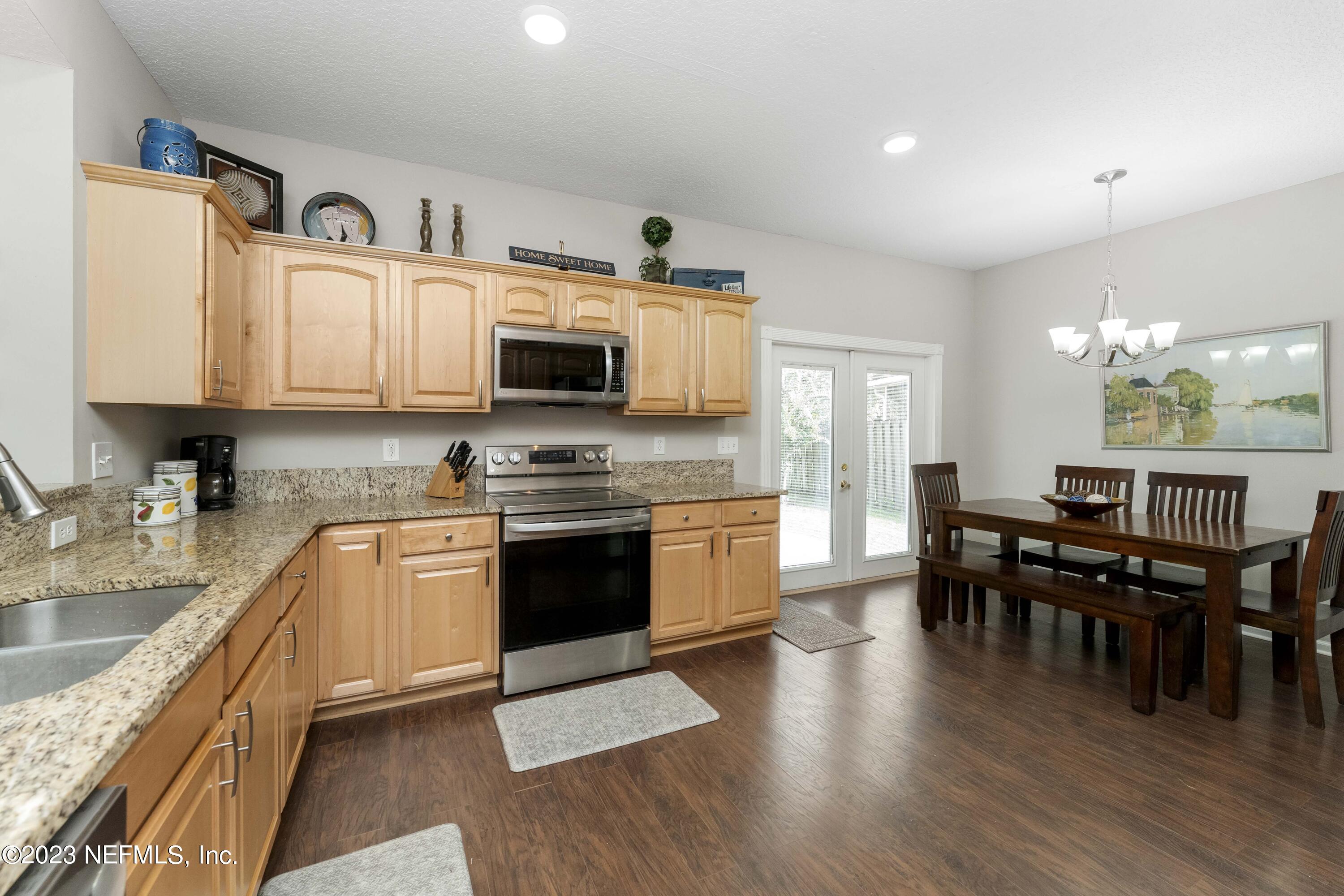 428 Sparrow Branch Circle St. Johns, FL 32259 - Photo 15 of 42 a kitchen with stainless steel appliances granite countertop a sink dishwasher a stove top oven a refrigerator with island and chairs