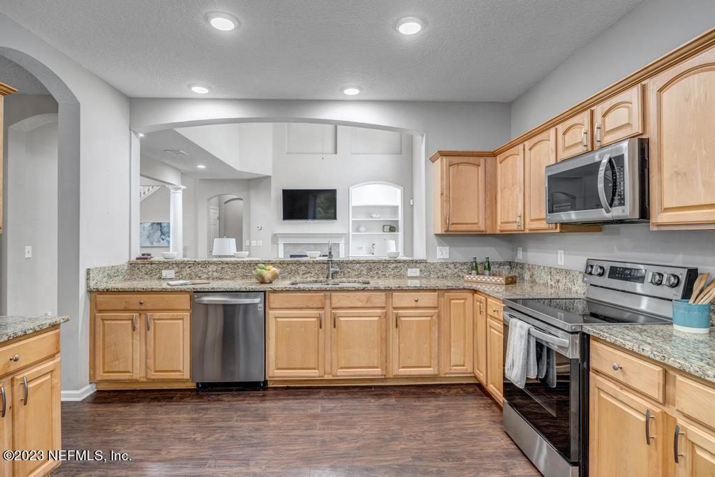 428 Sparrow Branch Circle St. Johns, FL 32259 - Photo 16 of 42 a kitchen with stainless steel appliances granite countertop a sink and stove top oven