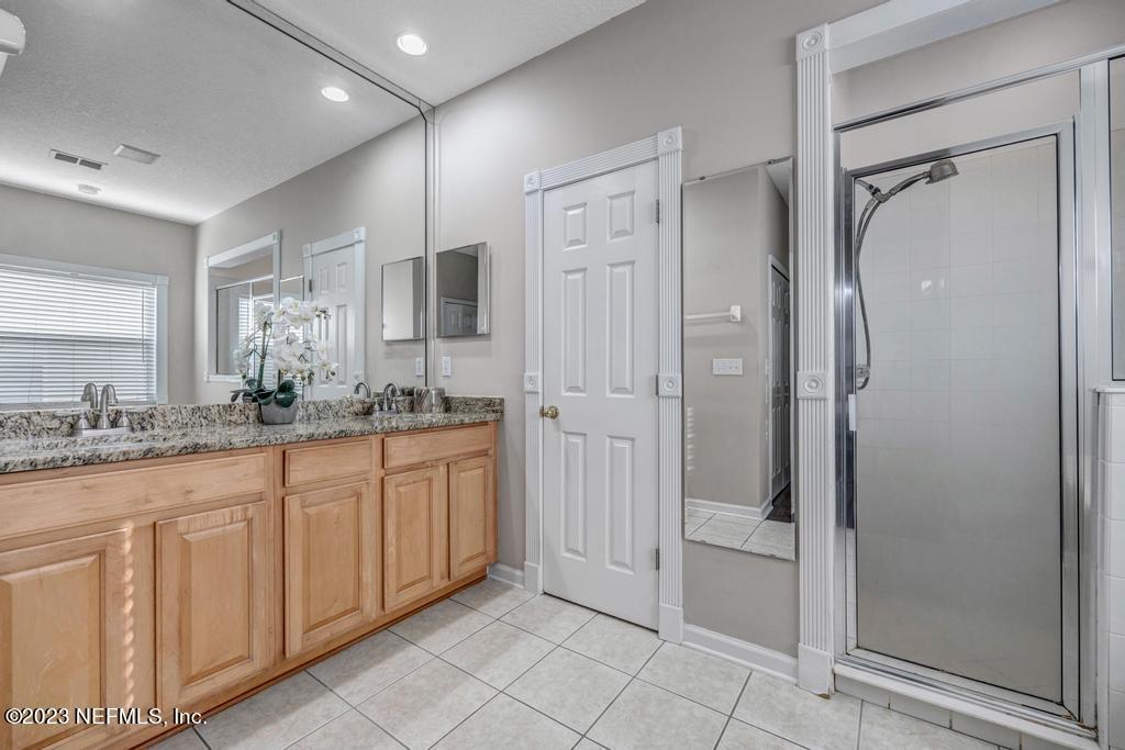 428 Sparrow Branch Circle St. Johns, FL 32259 - Photo 25 of 42 a spacious bathroom with a granite countertop sink mirror and shower