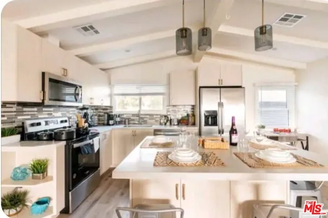 a kitchen with stainless steel appliances kitchen island granite countertop a sink and cabinets