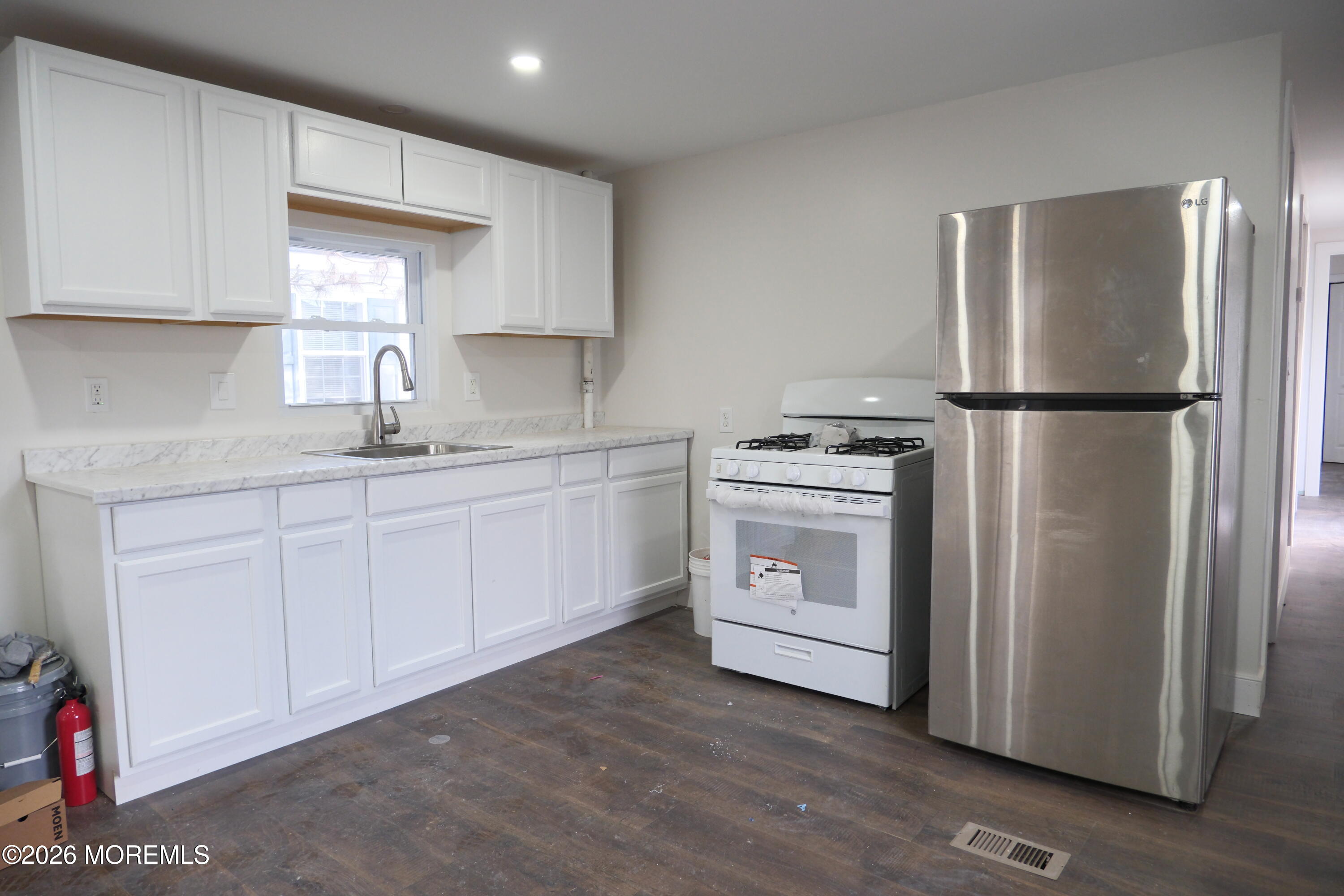 335 Adams Street Eatontown, NJ 07724 - Photo 1 of 7 a kitchen with a white refrigerator oven a sink dishwasher and white cabinets with wooden floor