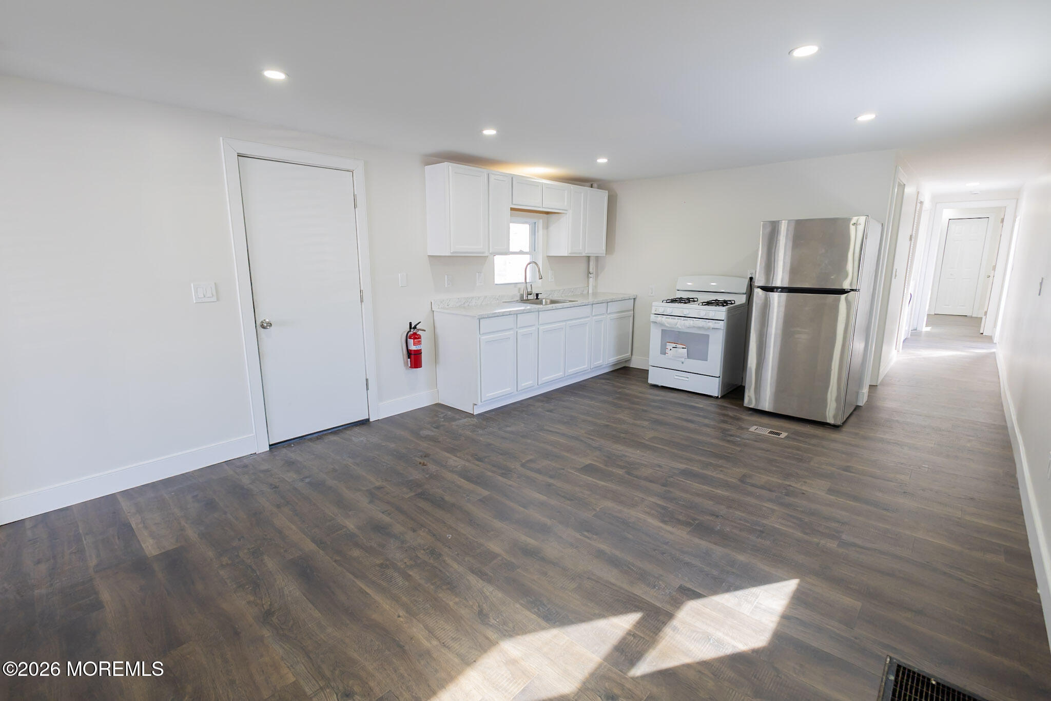 335 Adams Street Eatontown, NJ 07724 - Photo 3 of 10 a large white kitchen with wooden floor and stainless steel appliances