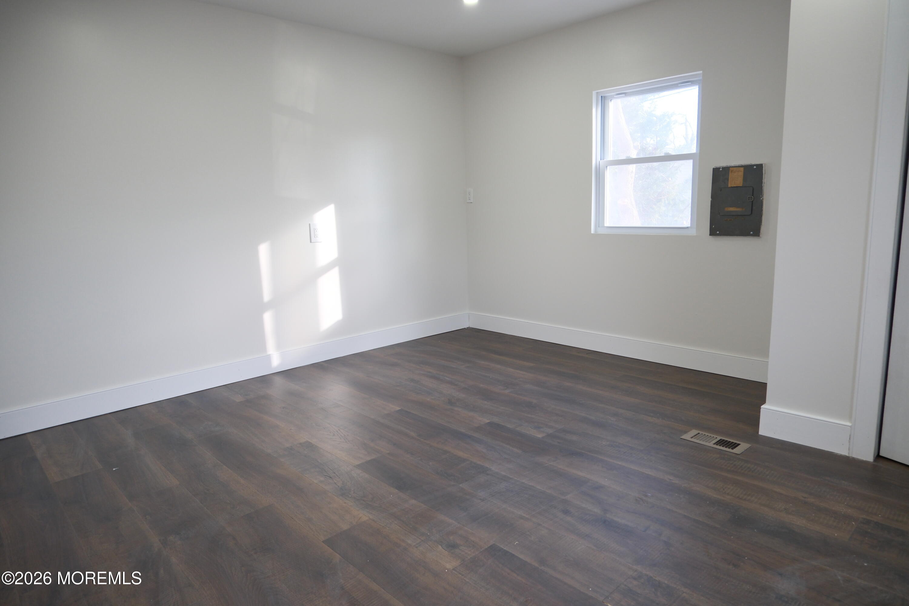335 Adams Street Eatontown, NJ 07724 - Photo 4 of 7 an empty room with wooden floor and windows