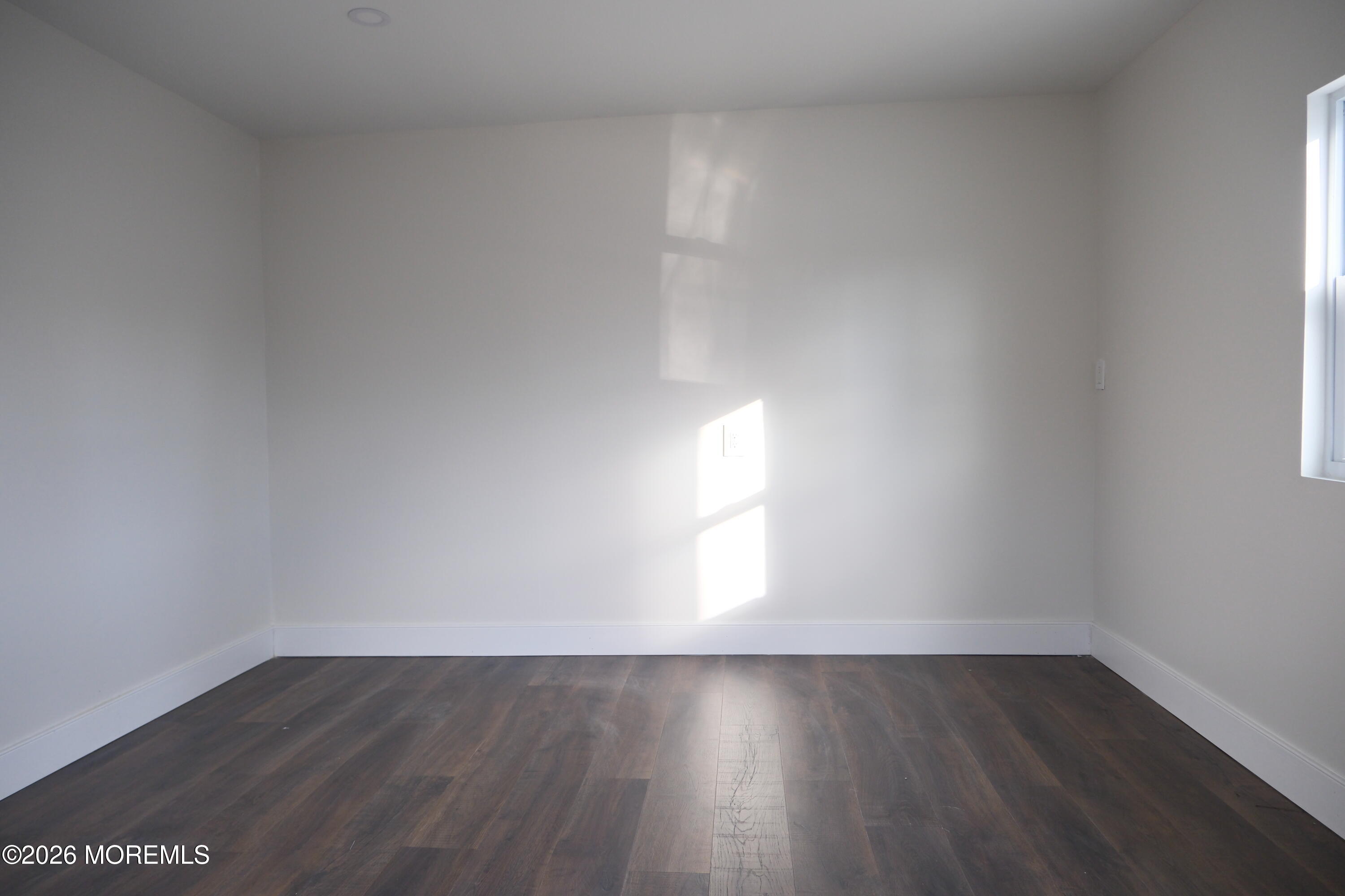 335 Adams Street Eatontown, NJ 07724 - Photo 5 of 7 a view of an empty room and wooden floor and window