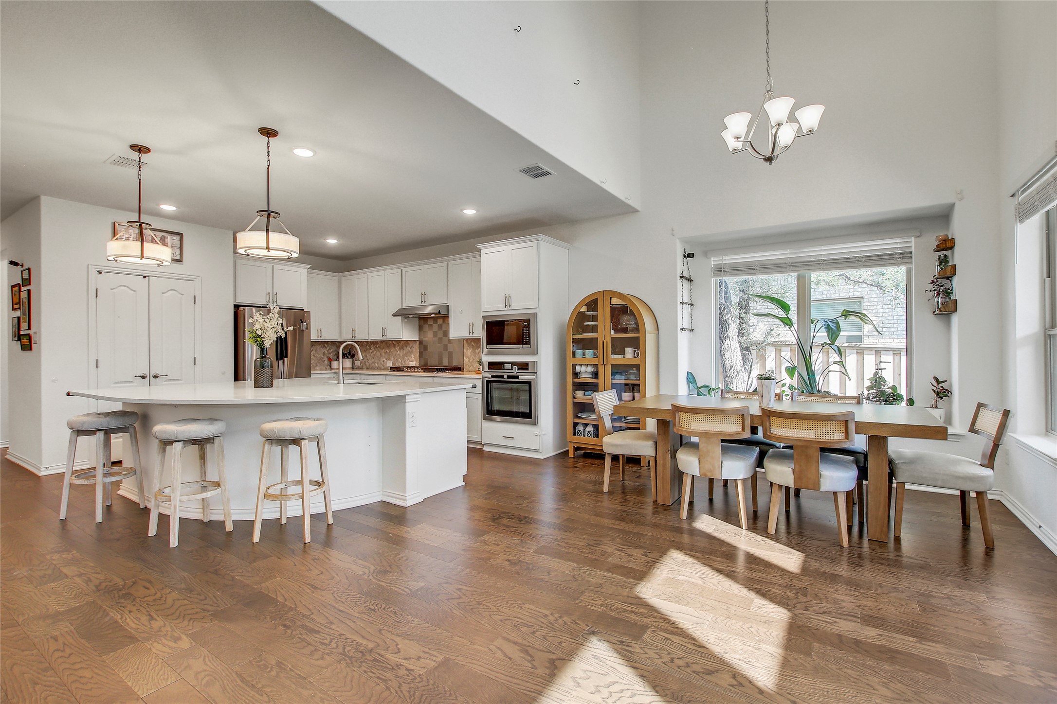 104 Millbend Road Georgetown, TX 78633 - Photo 7 of 40 An inviting open-concept kitchen and dining area features rich hardwood floors and abundant natural light.