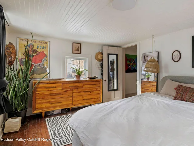 a bedroom with a bed and a painting on the wall