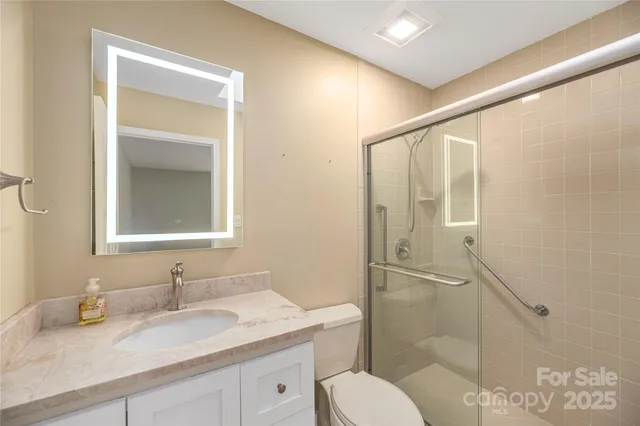 a bathroom with a granite countertop sink toilet and shower