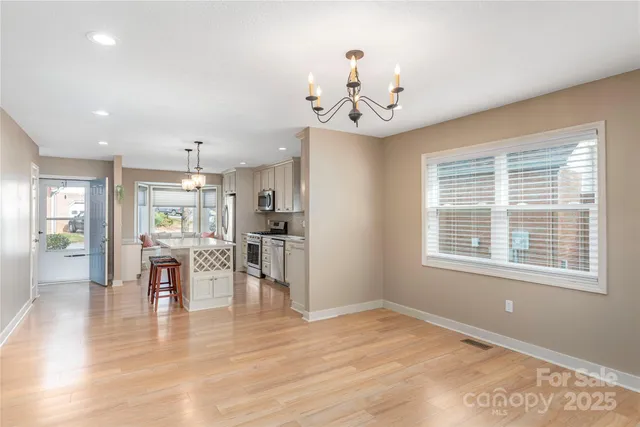 a view of a dining room with furniture a chandelier and wooden floor