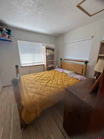 a view of a roof deck with table and chairs a barbeque with wooden floor and fence