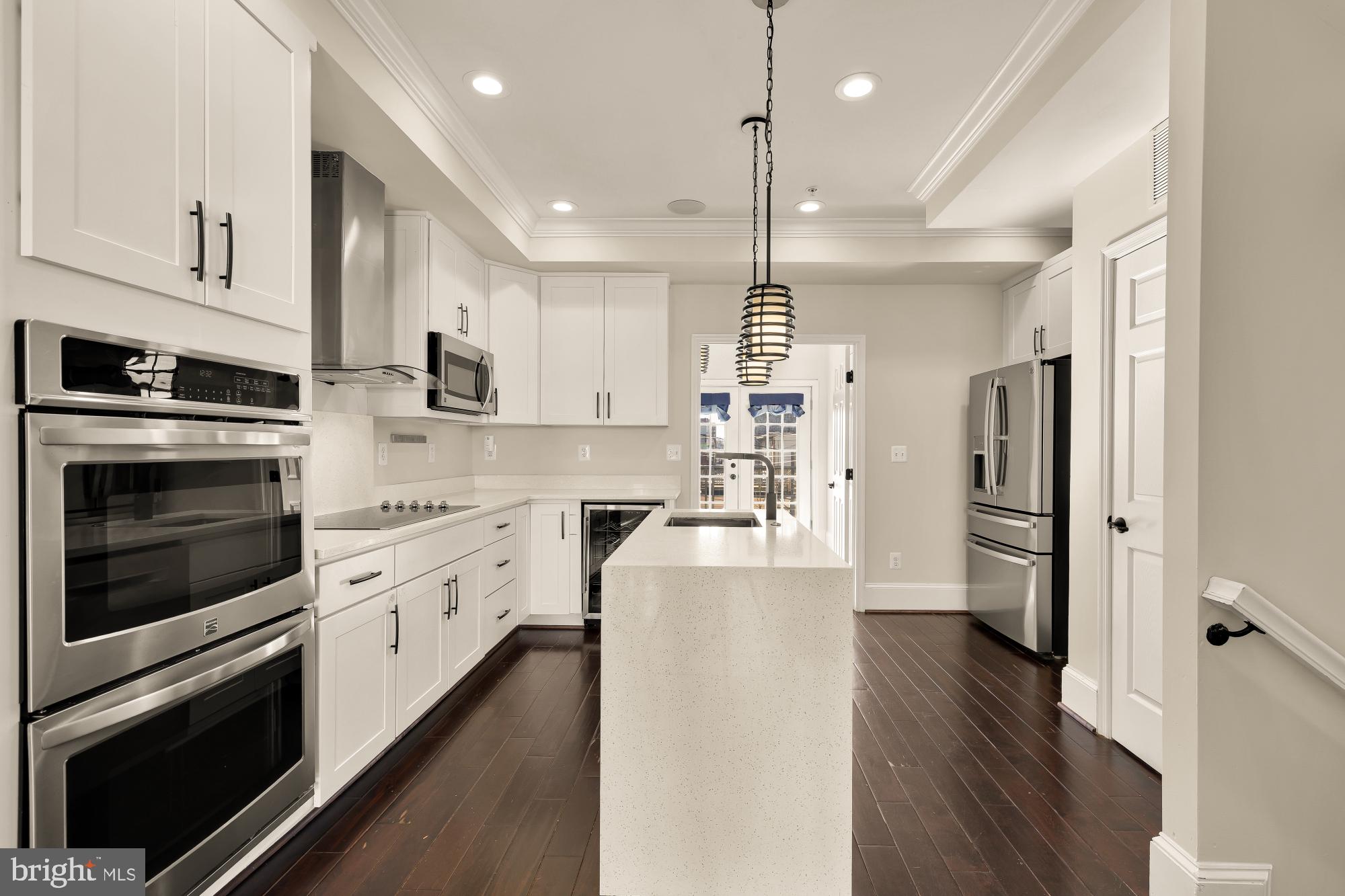 1609 Levis Street Northeast Washington, DC 20002 - Photo 6 of 35 a large kitchen with cabinets wooden floor and stainless steel appliances