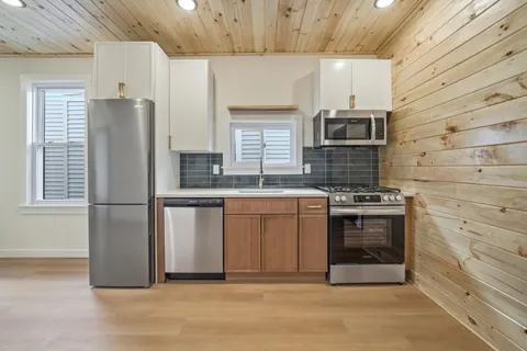 a kitchen with stainless steel appliances granite countertop a stove a sink and a refrigerator