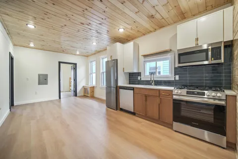 a large kitchen with stainless steel appliances granite countertop a stove and a refrigerator