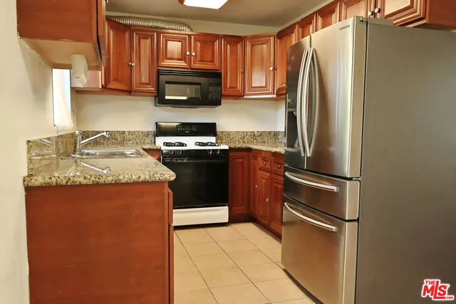 a kitchen with stainless steel appliances granite countertop a refrigerator stove microwave and sink